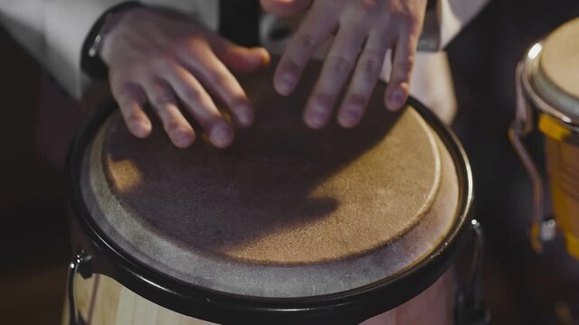 Men's hands banging on the hand drum
