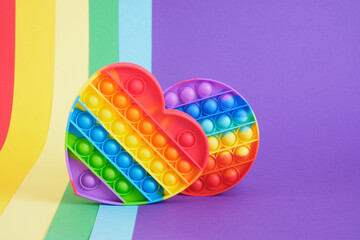 colorful antistress sensory toy fidget push pop it on rainbow background - obrazy, fototapety, plakaty