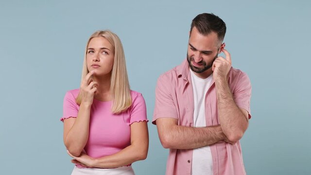 Fun young couple two friends family bearded man woman in pink clothes together think pointing index finger up with great new idea isolated on pastel plain light blue color background studio portrait