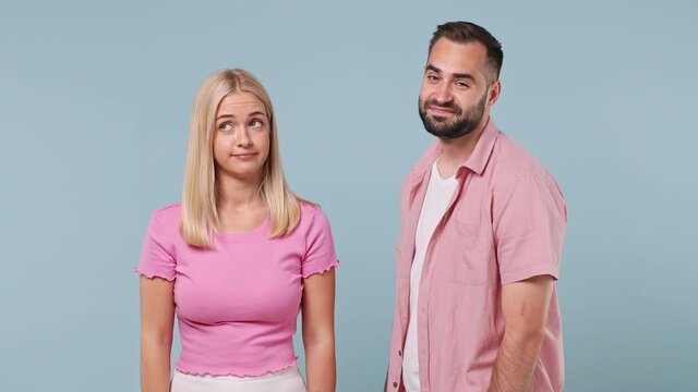 Young couple two friends family in pink clothes together man try want kiss woman but she doing stop palm gesture does not want it isolated on pastel plain light blue color background studio portrait