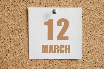 march 12. 12th day of the month, calendar date. White calendar sheet attached to brown cork board.Spring month, day of the year concept
