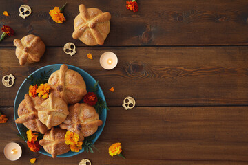 Day of the dead, Dia De Los Muertos celebration party Background With bread of death or Pan de Muerto, Skulls, marigolds flowers on dark wood table with Copy Space. Traditional Mexican culture  - obrazy, fototapety, plakaty