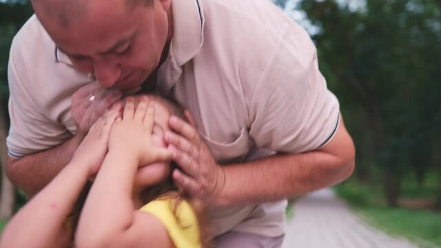 Father wanted to make a surprise to his little daughter, he came up from behind and closes eyes to his daughter with his hands, plating guess who.