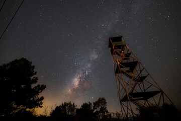 The firewatch tower under the milkyway in the night sky