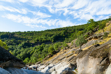 Fototapeta na wymiar Río en paisaje de montaña con cielo azul y nubes