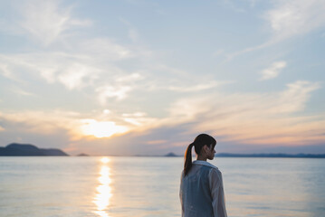 夕暮れの海にいる女性