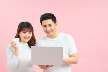 Couple with laptop and credit card in studio