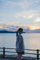 夕暮れの海にいる女性