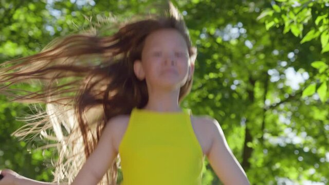 Close up portrait of asian girl jumping over rope in park on sunny summer day