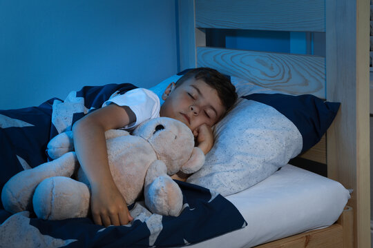 Cute little boy sleeping with teddy bear at home. Bedtime - Powered by Adobe