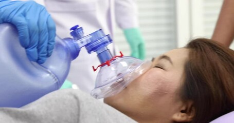 Close up video shot, team of medical person, doctor and nurse, moving female patient on bed and using resuscitator face mask, ambu bag equipment help for breathing in emergency case.