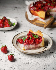 Strawberry cake with ricotta cheese. Summer dessert with berries and mint on a white table. A piece of cake on a ceramic plate. Fresh homemade cakes