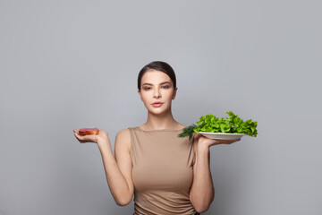 Dieting concept. Young cute woman choosing between vegetable and unhealthy food