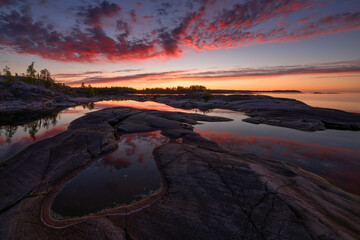 Puddles on the rocky shore of the lake at dawn