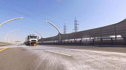 Cleaning sweeper machine wash asphalt road with water spray.