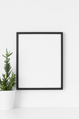 Black frame mockup on the wall with a  aloe vera.