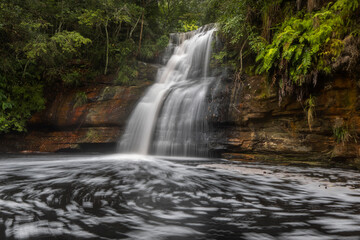 a waterfall with trees on the side of a river