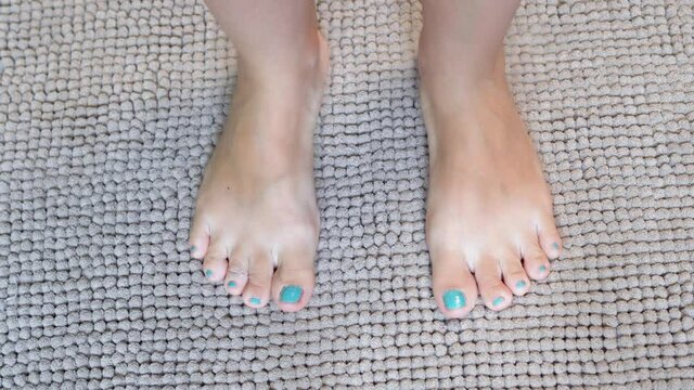 The Girl's Feet are on a Soft Plump Rug in the Bathroom.