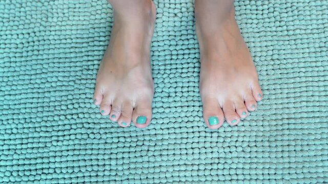 Feet Step on a Soft Turquoise Blue Rug. Feet on a Fluffy Carpet, Close-up.