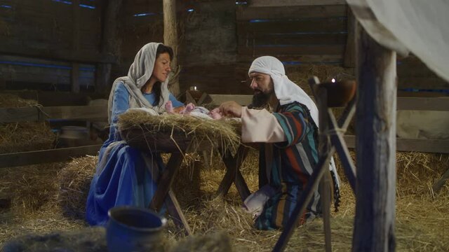 Mary and Joseph speaking and taking care of baby Jesus nativity scene