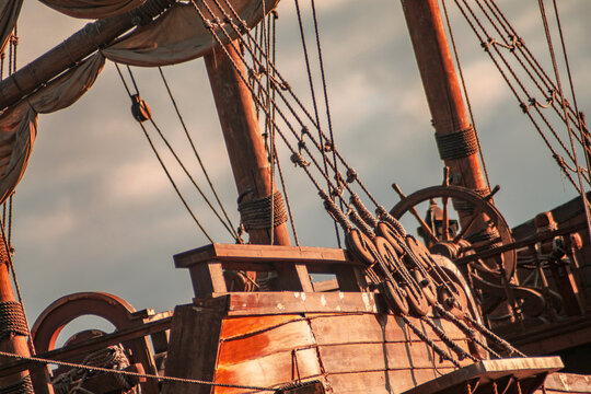 Part of an old pirate ship close-up. The sails, rudder and wooden boards are visible.