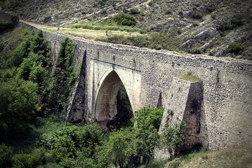Fototapeta na wymiar A stone bridge crossing the valley from the mountainside to the village of Bocairent