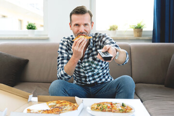 Man watching TV while eating pizza