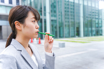 電子タバコを吸う若いビジネスウーマン