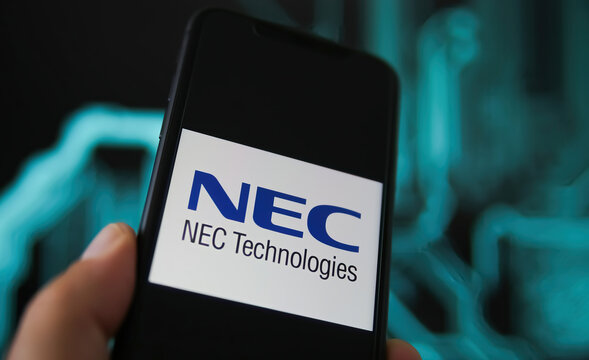 Viersen, Germany - May 9. 2021: Closeup of phone screen with logo lettering of nec corporation, blurred power circuit background