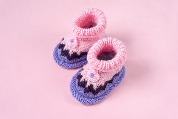 Knitted Baby booties on pink  background