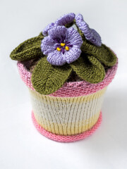 Knitted violet flower on a white background.