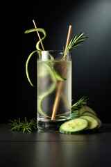 Cold refreshing drink with ice, cucumber, and rosemary.