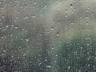 Background of glass covered with falling drops of heavy rain.