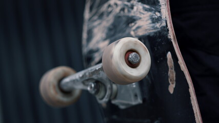 Wheel spinning on longboard. Black skateboard circling on grey background.