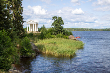 VYBORG, Leningrad REGION, RUSSIA-JULY, 19, 2021: view of the white temple of Neptune and the green...