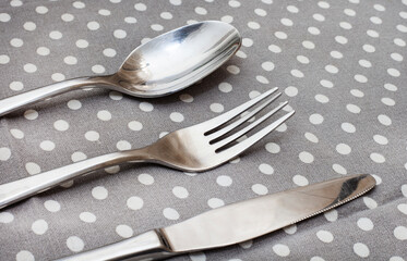 cutlery on a patterned grey and white polka dot tablecloth