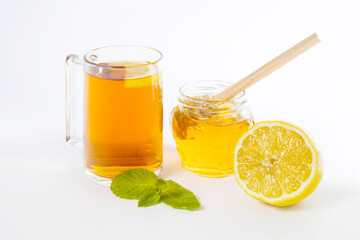 Glass of tea with honey, lemon and mint on white background.