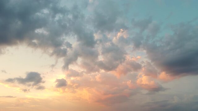 Beautiful clouds move in the sunlight against the blue sky. Time lapse, evening sky at sunset. Weather, cloudy nature background, time lapse. Video, footage for transition or intro. UHD 4K.