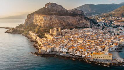Sunrise over harbor in Cefalu, Sicily, Italy, panoramic aerial view of old town with colorful waterfront houses, sea and La Rocca cliff.Attractive summer cityscape,travel holiday concept background. © Eva