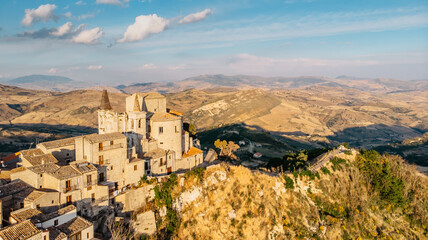 Aerial view of medieval stone village,the highest village in Madonie mountain range,Sicily,Italy.Church of Santa Maria di Loreto at sunset.Picturesque stone houses,narrow cobbled streets,views of town - obrazy, fototapety, plakaty