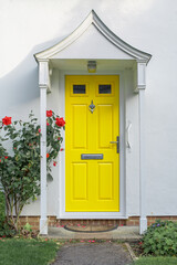 Beautiful yellow front door of English flat house 