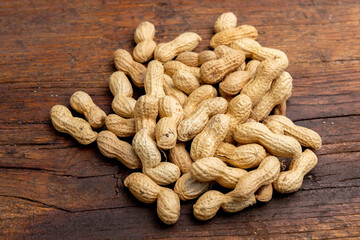 A lot of penuts on wooden background