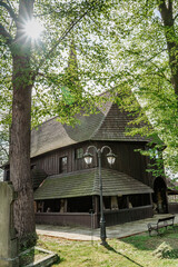 Broumov, Czech republic.Wooden Church Of St. Mary from 13th century with old cemetery.Renaissance and Empire style tombstones and graves.Fresh spring day. Religious RIP scenery