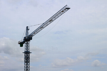 Industrial construction cranes on sky background