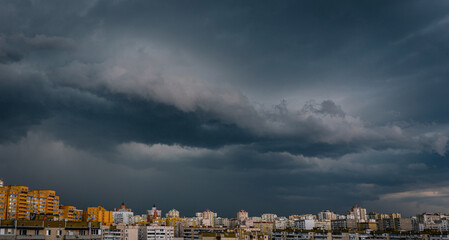 Dramatic stormy sky over modern city residential district. Low angle panorama.