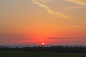 Colorful bright sunset in the field with clouds.