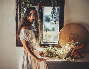 Exotic woman with shamanic drum and the herbs.