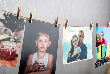 Family photo cards hang with clothespins on rope. Memories. Home photo gallery, original photo...
