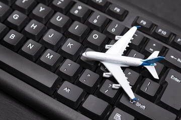 Airplane model on a computer keyboard. Buying air tickets online.