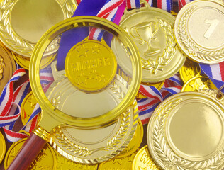 Magnifying glass on gold medals background. Sport results review concept.